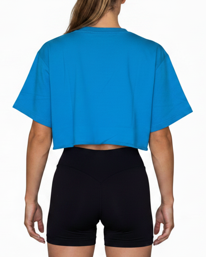 Person wearing a blue crop top and black shorts on a white background