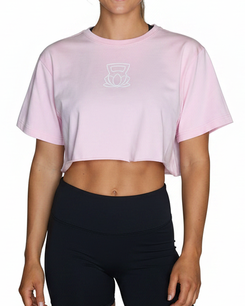 Person wearing a pink crop top and black shorts on a white background