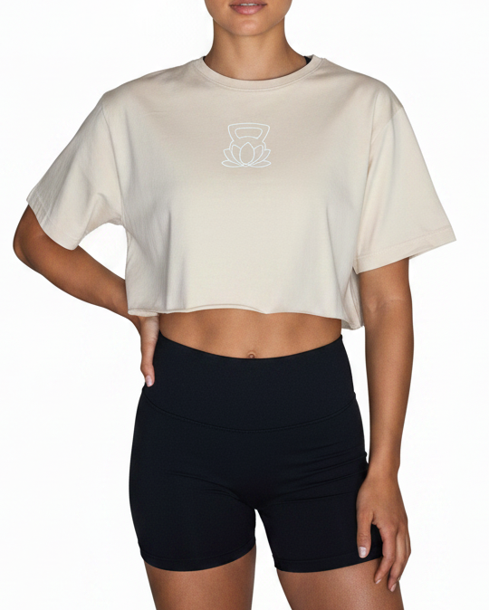 Woman wearing a beige cropped t-shirt and black shorts on a white background