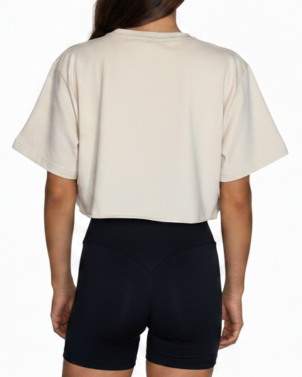Person wearing a beige t-shirt and black shorts on a white background