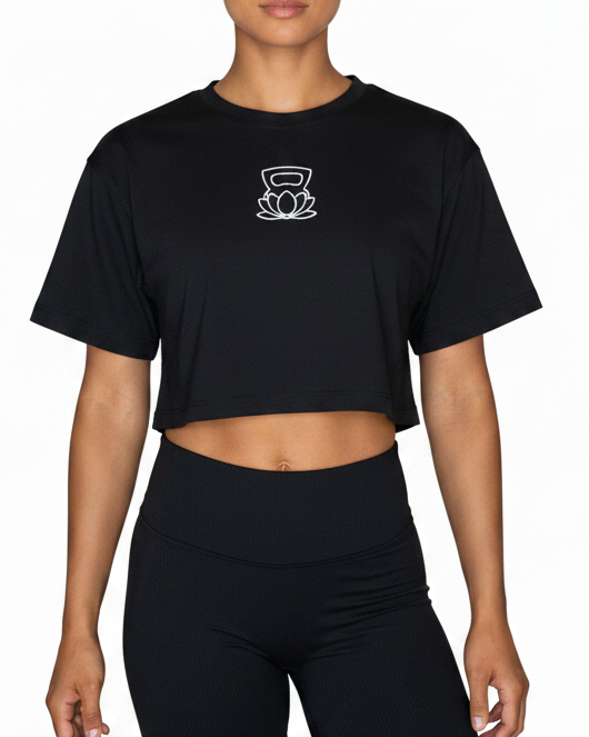 Person wearing a black crop top and black shorts on a white background