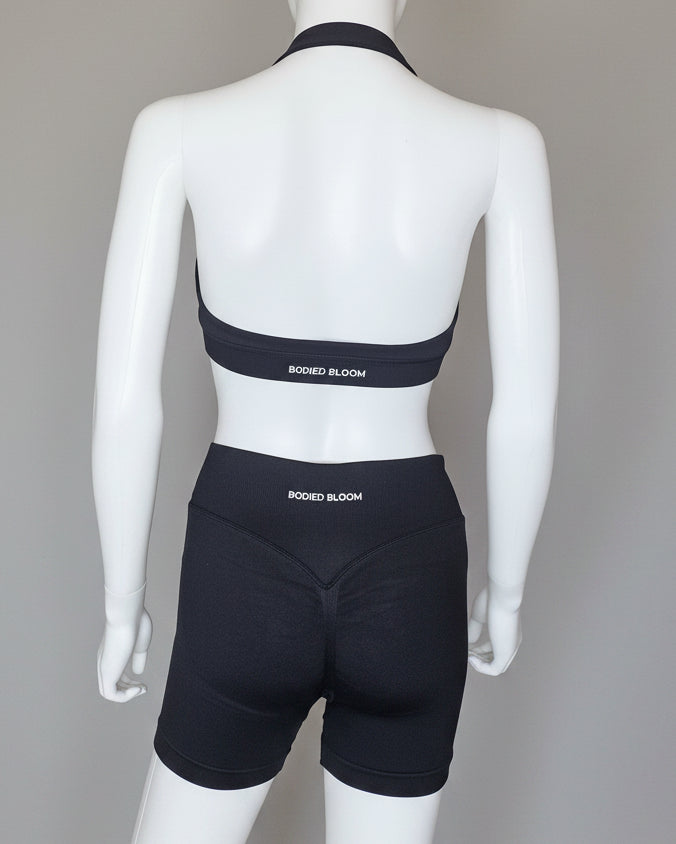 Woman wearing a black sports bra and shorts